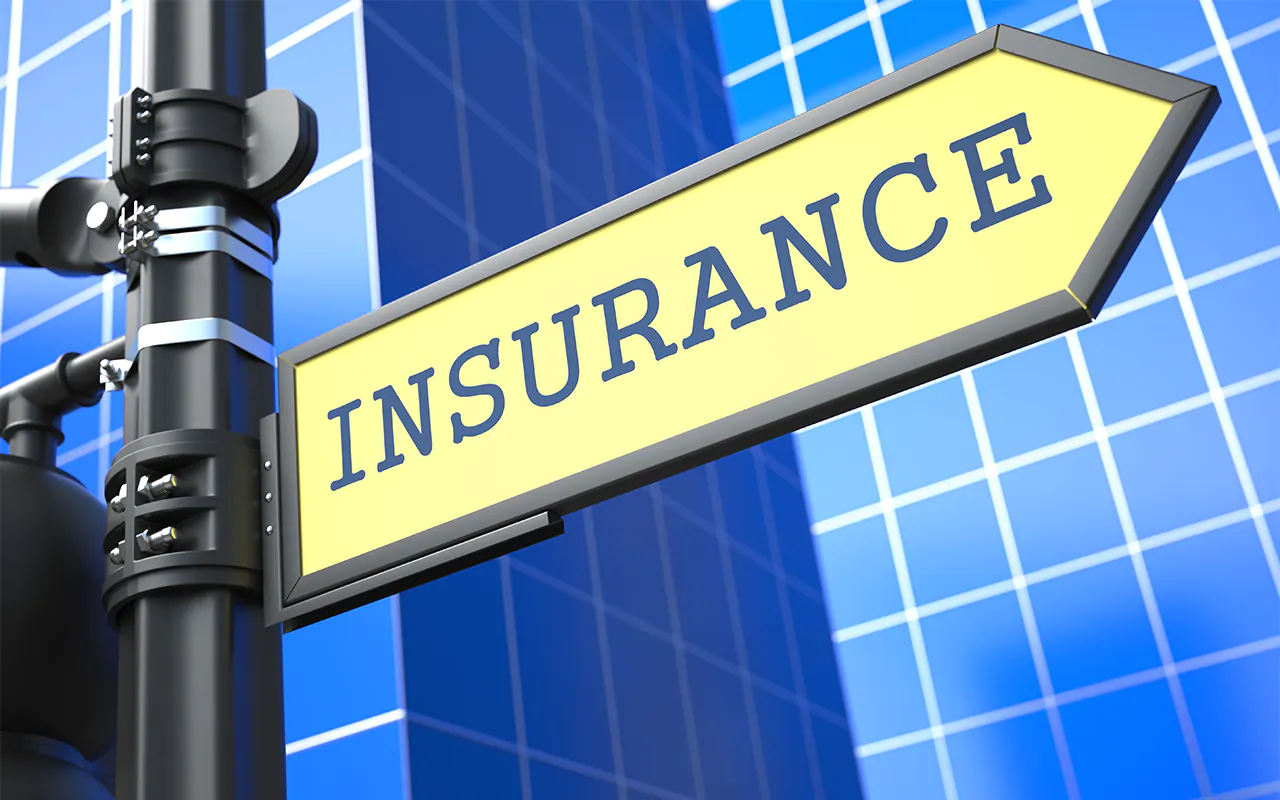 insurance written on street sign with skyscraper on background