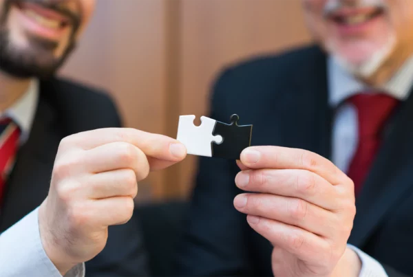 Two men holding jigsaw pieces