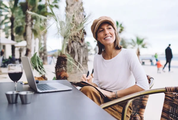 Woman with laptop working remote in a beach location